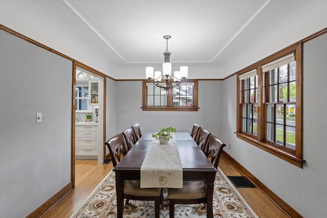 127 W 25th Ave, Spokane, WA 99203 - dining room featuring a tray ceiling, an inviting chandelier, baseboards, light wood finished floors, and visible vents