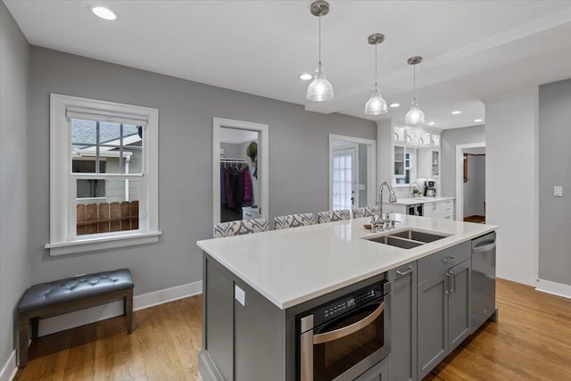 127 W 25th Ave, Spokane, WA 99203 - kitchen with light countertops, oven, a sink, light wood-type flooring, and gray cabinetry