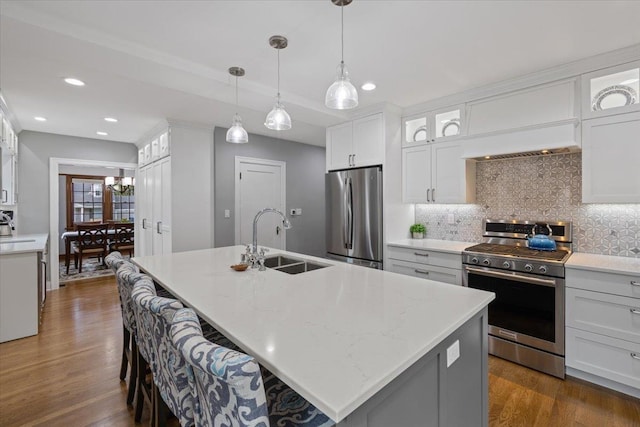 127 W 25th Ave, Spokane, WA 99203 - kitchen featuring white cabinetry, dark wood finished floors, backsplash, a sink, and appliances with stainless steel finishes