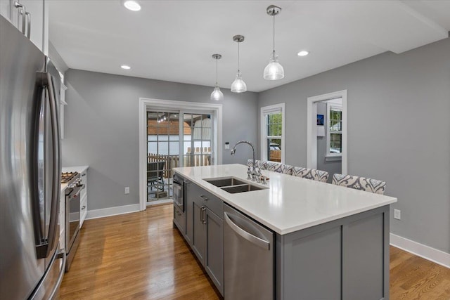 127 W 25th Ave, Spokane, WA 99203 - kitchen featuring gray cabinets, light countertops, a sink, light wood finished floors, and stainless steel appliances