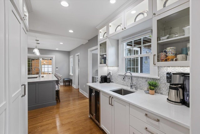 127 W 25th Ave, Spokane, WA 99203 - kitchen with white cabinetry, a sink, backsplash, and wood finished floors