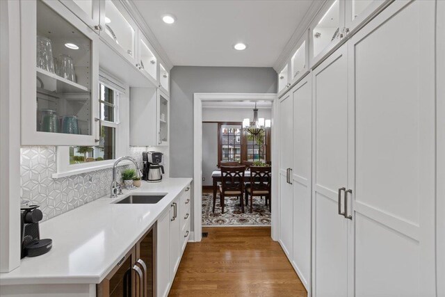 127 W 25th Ave, Spokane, WA 99203 - kitchen with decorative backsplash, white cabinets, wood finished floors, glass insert cabinets, and a sink