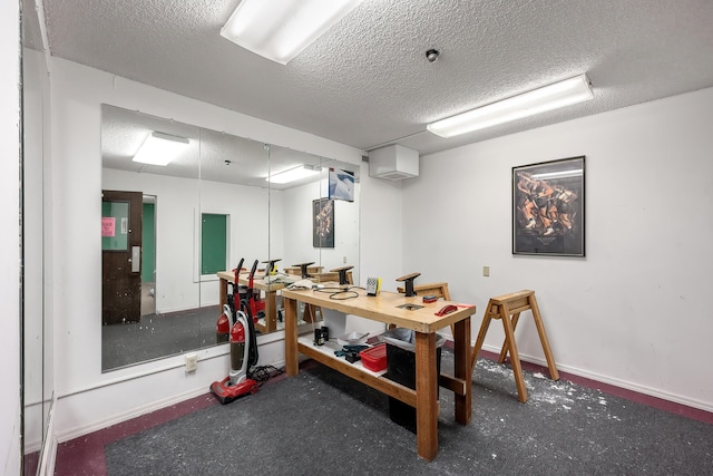 office area featuring baseboards, a textured ceiling, and a workshop area