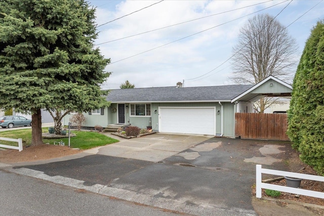 ranch-style house featuring a shingled roof, driveway, a garage, and fence