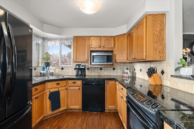 kitchen with tile counters, dark wood-style floors, backsplash, black appliances, and a sink
