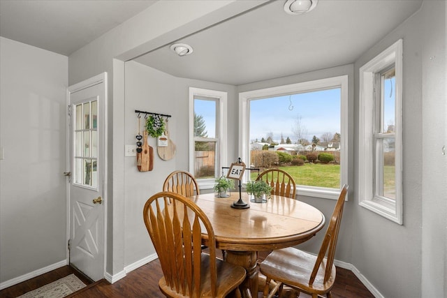 dining space featuring baseboards, dark wood-style floors, and a healthy amount of sunlight