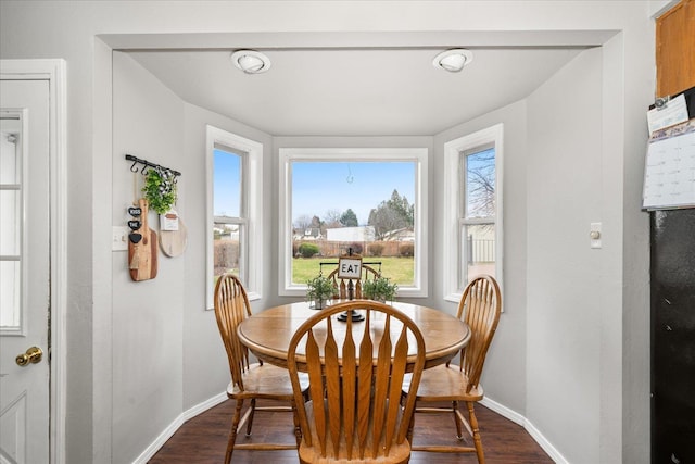 dining space with baseboards, dark wood-style floors, and plenty of natural light