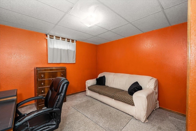 carpeted home office featuring a textured wall, a drop ceiling, and baseboards