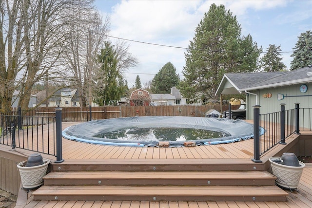 wooden terrace featuring a jacuzzi and a fenced backyard
