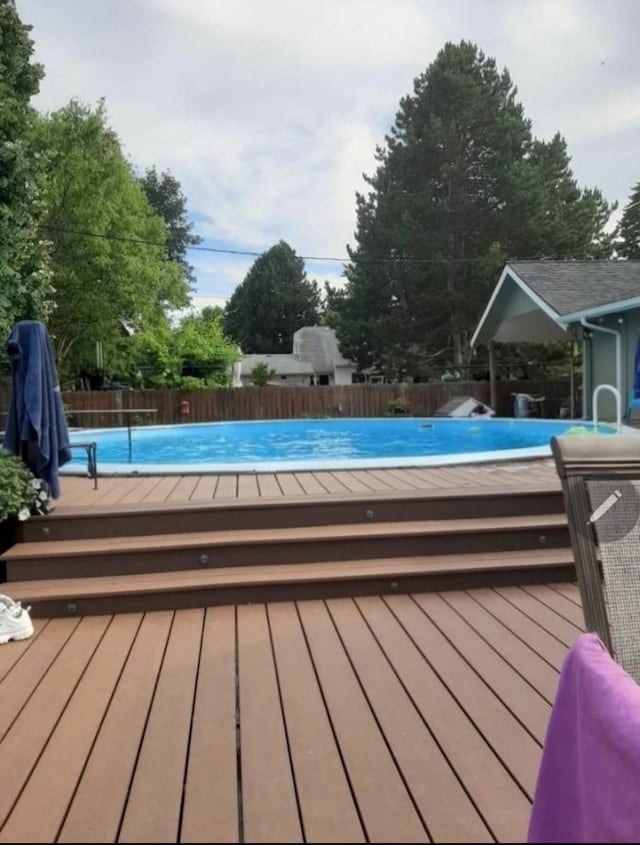 view of swimming pool with a fenced in pool, fence, and a deck