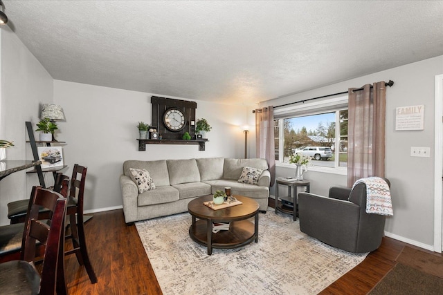 living area with baseboards, wood finished floors, and a textured ceiling