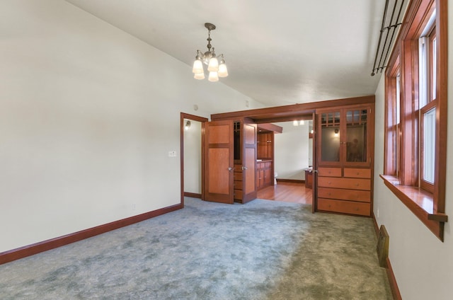 carpeted empty room with an inviting chandelier, baseboards, and plenty of natural light