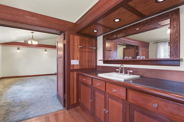 bathroom with baseboards, a notable chandelier, wood finished floors, and vanity