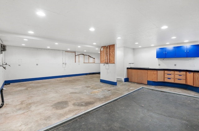garage with baseboard heating, baseboards, and recessed lighting