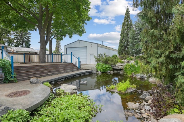 view of yard with a small pond, an outbuilding, and a detached garage