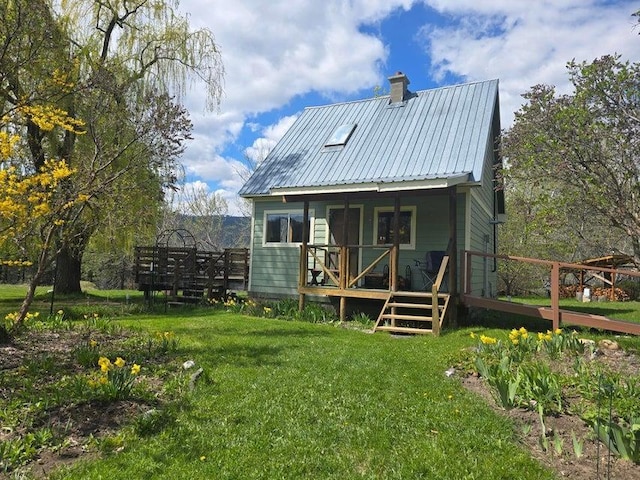 3434G Rockcut Rd, Kettle Falls, WA 99141 - back of house featuring a lawn, metal roof, a chimney, and a deck