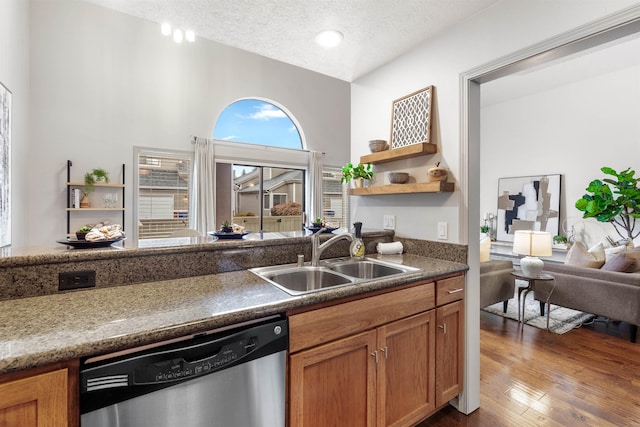 kitchen with stainless steel dishwasher, a sink, open shelves, dark wood-style flooring, and brown cabinetry