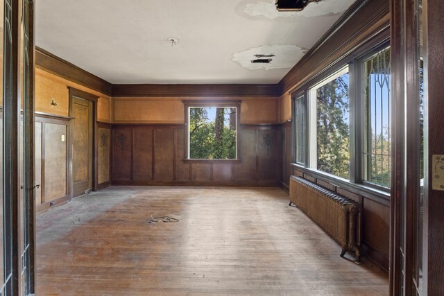 540 E Rockwood Blvd, Spokane, WA 99202 - empty room with light wood-style flooring, radiator heating unit, and wooden walls