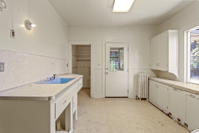 540 E Rockwood Blvd, Spokane, WA 99202 - kitchen with radiator, light floors, white cabinets, light countertops, and a sink