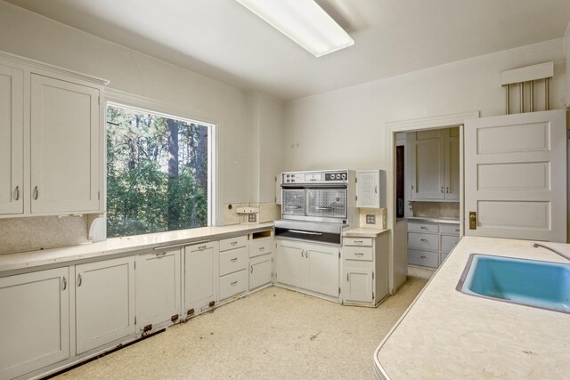 540 E Rockwood Blvd, Spokane, WA 99202 - kitchen with white cabinetry, a warming drawer, light countertops, a sink, and oven