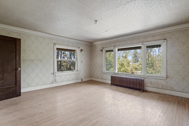 540 E Rockwood Blvd, Spokane, WA 99202 - empty room with baseboards, hardwood / wood-style flooring, a textured ceiling, wallpapered walls, and radiator heating unit