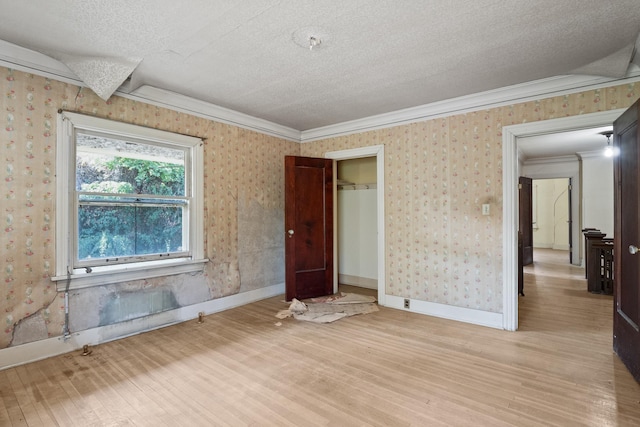 540 E Rockwood Blvd, Spokane, WA 99202 - unfurnished bedroom featuring crown molding, a textured ceiling, light wood finished floors, and wallpapered walls