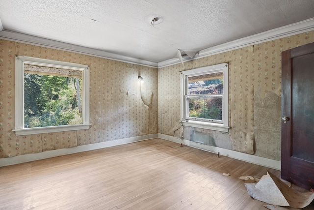 540 E Rockwood Blvd, Spokane, WA 99202 - spare room featuring ornamental molding, a healthy amount of sunlight, hardwood / wood-style floors, and wallpapered walls