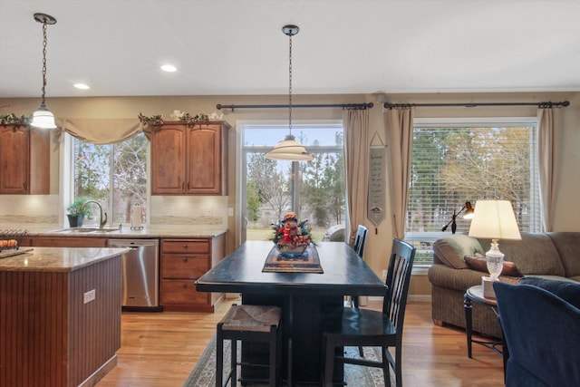 4357 S Greystone Ln, Spokane, WA 99203 - kitchen with a sink, open floor plan, light wood-style floors, stainless steel dishwasher, and light stone counters