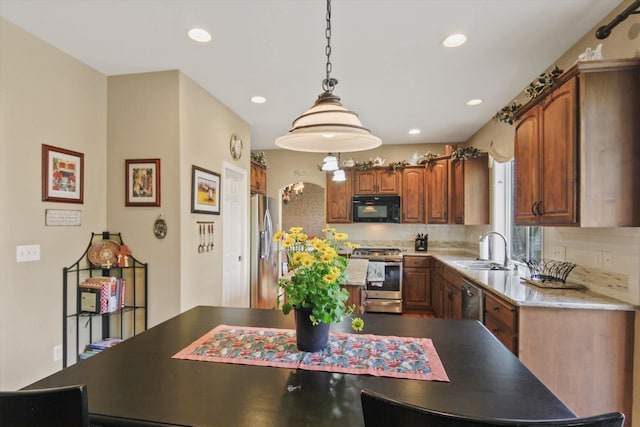 4357 S Greystone Ln, Spokane, WA 99203 - kitchen with brown cabinetry, decorative backsplash, a sink, and stainless steel appliances