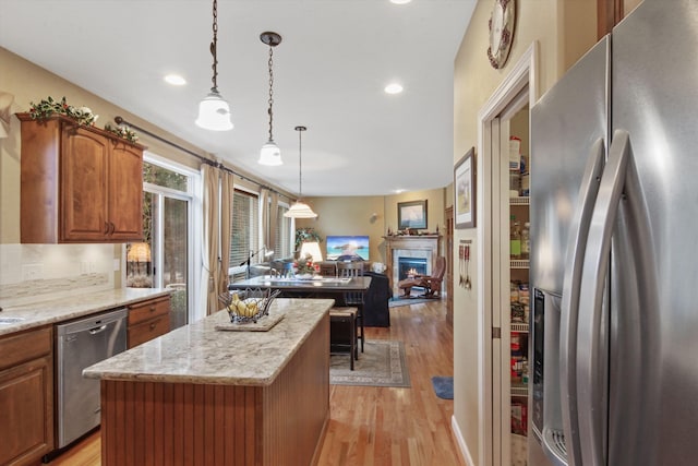 4357 S Greystone Ln, Spokane, WA 99203 - kitchen with light wood finished floors, brown cabinets, a kitchen island, and stainless steel appliances