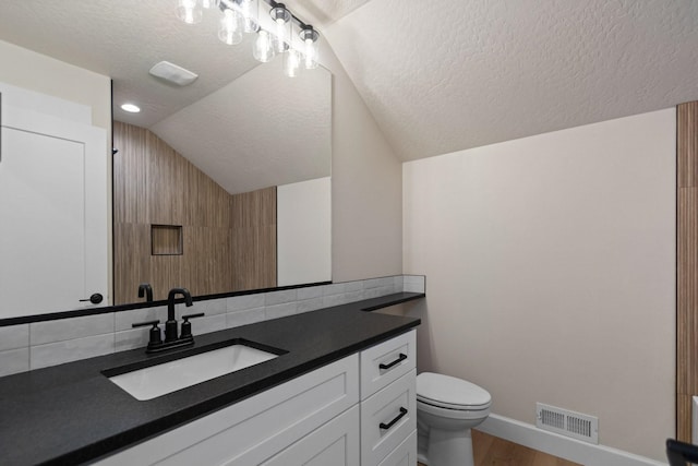 13310 N Starling Ln, Spokane, WA 99208 - bathroom with vanity, vaulted ceiling, visible vents, toilet, and wood finished floors