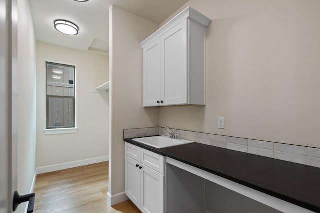 13310 N Starling Ln, Spokane, WA 99208 - washroom featuring a sink, baseboards, and light wood-type flooring