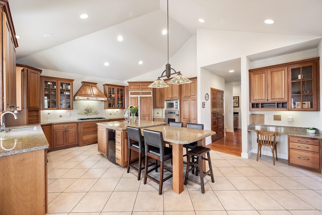 13615 N Riverbluff Ln, Spokane, WA 99208 - kitchen with a kitchen bar, built in appliances, a sink, and custom range hood