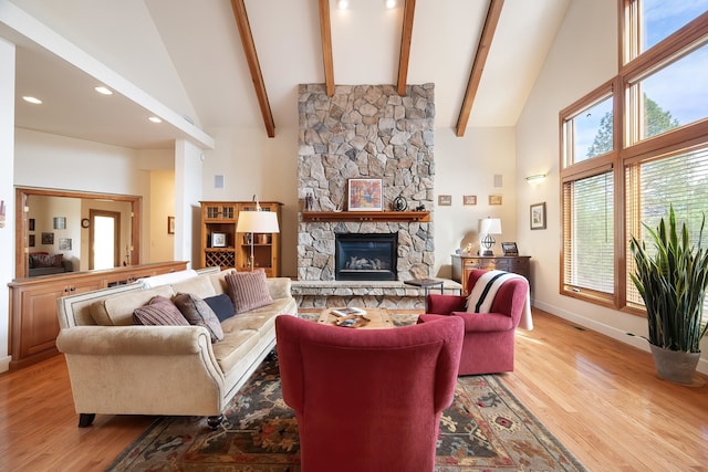 13615 N Riverbluff Ln, Spokane, WA 99208 - living room featuring baseboards, a stone fireplace, light wood-style floors, beam ceiling, and high vaulted ceiling
