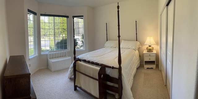 bedroom with baseboards and light carpet