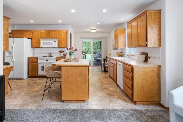 2603 S Sunnybrook Ln, Spokane, WA 99037 - kitchen with white appliances, a kitchen island, light countertops, decorative backsplash, and recessed lighting