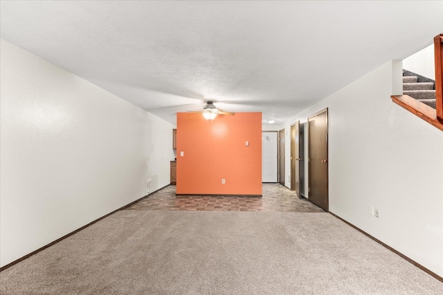 2121 E Upriver Dr Unit # 61, Spokane, WA 99207 - unfurnished living room featuring baseboards, a ceiling fan, carpet, a textured ceiling, and stairs