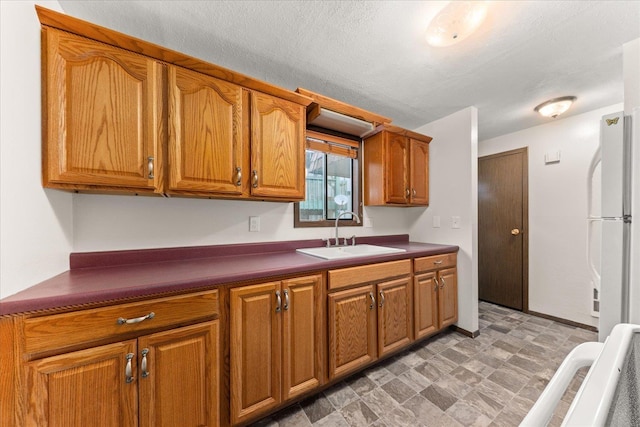 2121 E Upriver Dr Unit # 61, Spokane, WA 99207 - kitchen featuring a sink, freestanding refrigerator, dark countertops, and brown cabinets