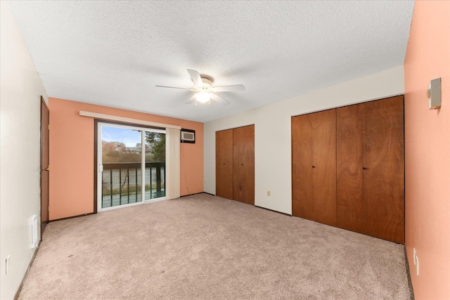 2121 E Upriver Dr Unit # 61, Spokane, WA 99207 - unfurnished bedroom with two closets, a textured ceiling, light colored carpet, a ceiling fan, and access to exterior