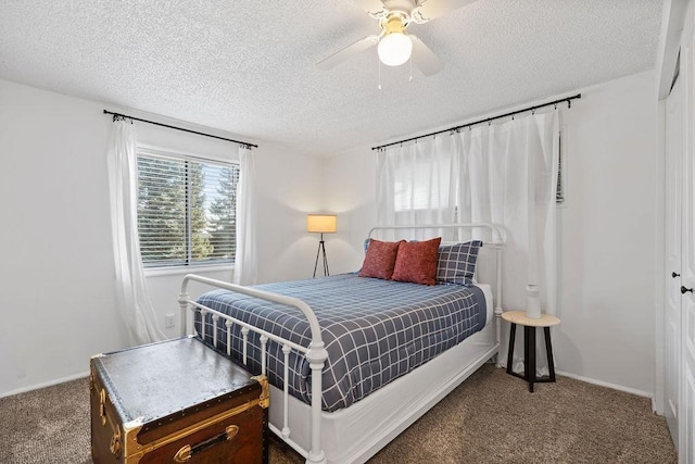 carpeted bedroom featuring a closet, a textured ceiling, baseboards, and ceiling fan