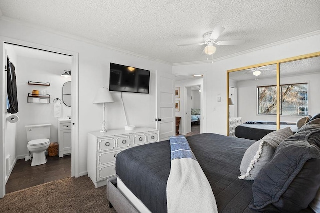 bedroom featuring a closet, a textured ceiling, crown molding, connected bathroom, and dark carpet