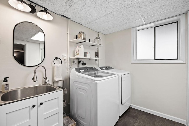washroom featuring independent washer and dryer, baseboards, laundry area, and a sink