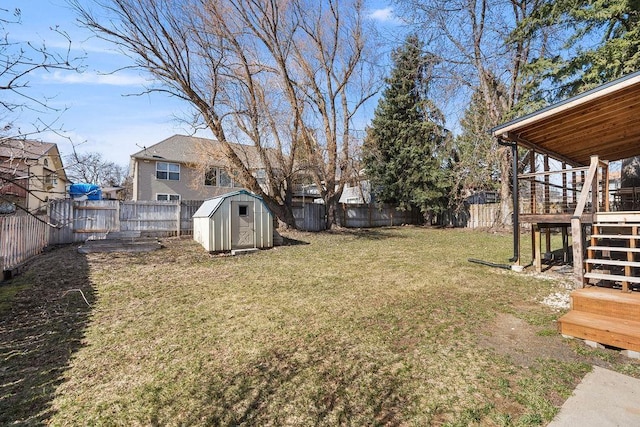 view of yard with a fenced backyard, an outdoor structure, stairs, and a storage unit
