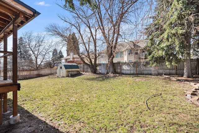 view of yard featuring a fenced backyard, a storage unit, and an outdoor structure