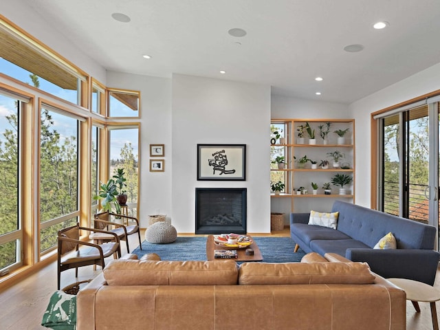 living room with wood finished floors, a fireplace, vaulted ceiling, and recessed lighting
