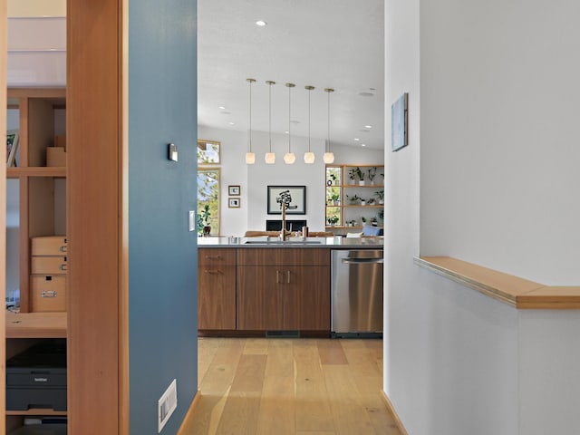kitchen with hanging light fixtures, a sink, light wood-type flooring, recessed lighting, and stainless steel dishwasher