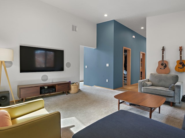 carpeted living area with recessed lighting, a towering ceiling, and visible vents