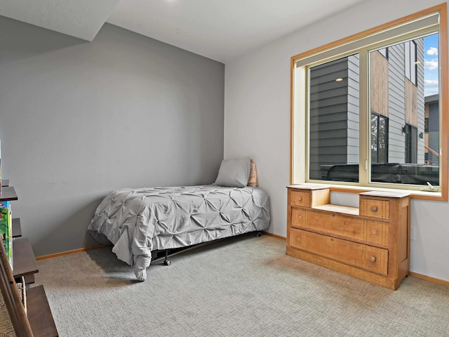 bedroom featuring light colored carpet and baseboards