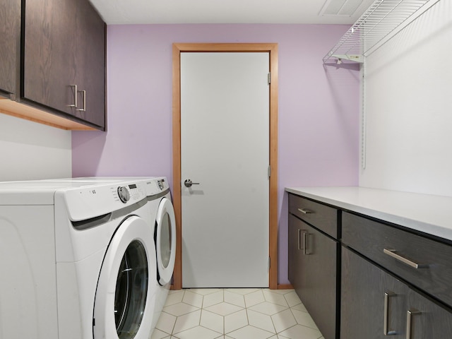 laundry area with light tile patterned floors, separate washer and dryer, and cabinet space