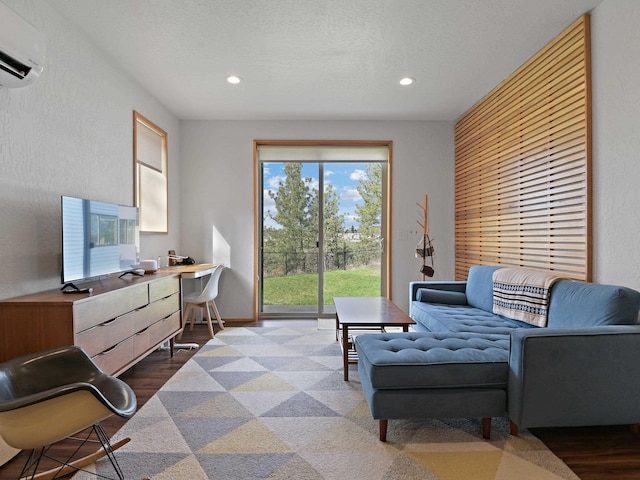 living room featuring a textured ceiling, recessed lighting, a wall mounted AC, wood finished floors, and a textured wall